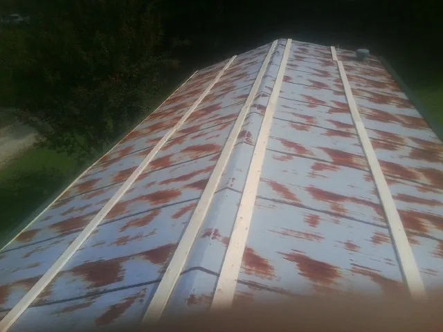 Rusted metal roof panels with new wood purlins before replacement — Storm Damage Roof Repair in Wheaton by Roofing Brothers