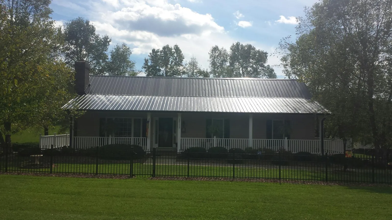 Gray metal roof on a brick ranch with a full width front porch — Gutter Guard Installation work by our crew in Wheaton